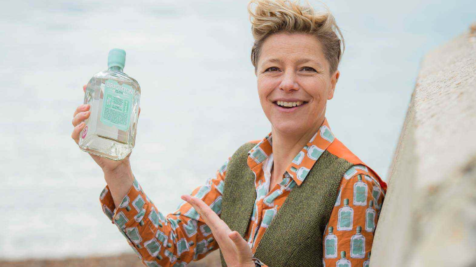 Kathy from Brighton Gin holding a bottle of their gin