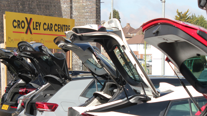 Cars parked in a garage with open boots