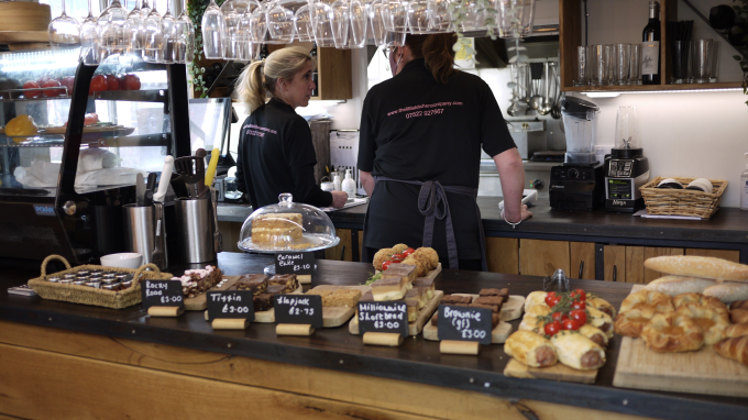 Two people behind a counter in a cafe