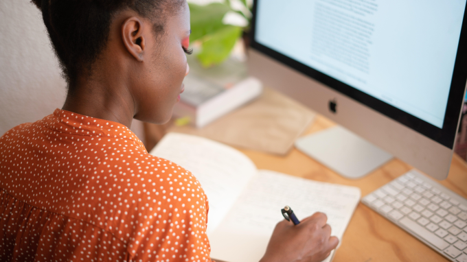 Person working at a desk in front of a monitor