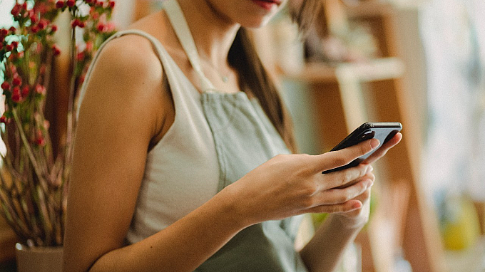 person working in a shop using their phone