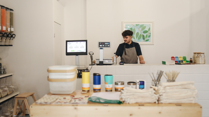 Man at a shop counter using a till