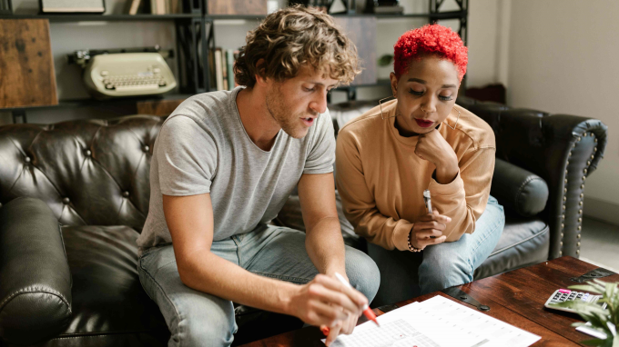 Couple on a sofa reviewing paperwork